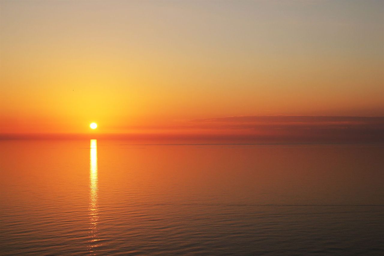 Warm golden sunset over a calm open sea